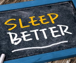 A picture of black bloard with text reading SLEEP BETTER