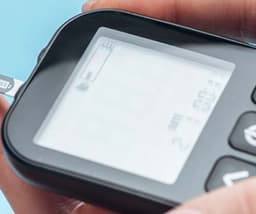 A picture of a hand holding a diabetes monitoring device