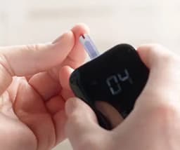 A picture of a hand holding a diabetes monitoring device